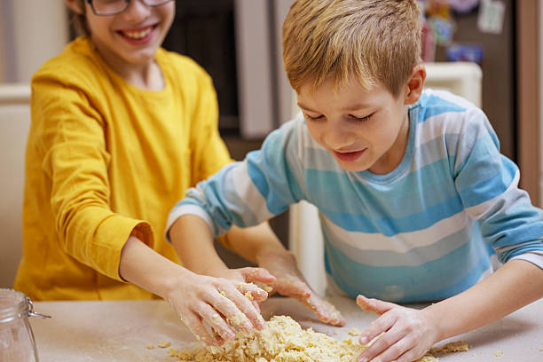 istock Children kneading dough together. 588597840