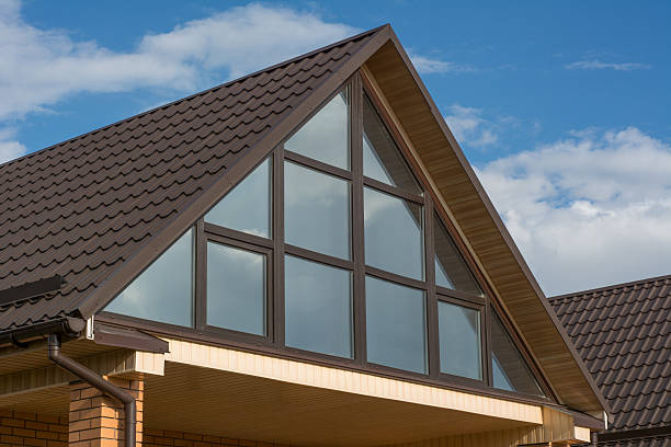 istock Attic panoramic window under the roof reflects clouds sky 588598384