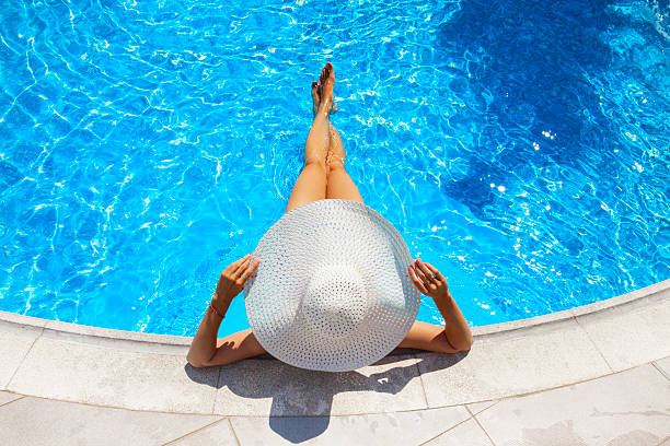 istock woman relaxing at a resort swimming pool 588599300