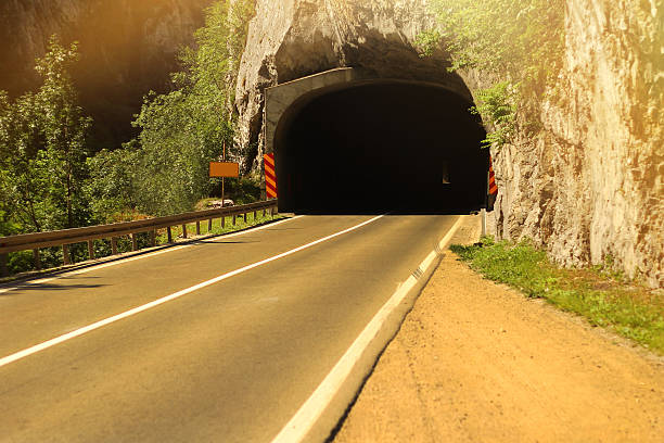 carretera con túnel y luz solar - copy space road sign sky above fotografías e imágenes de stock