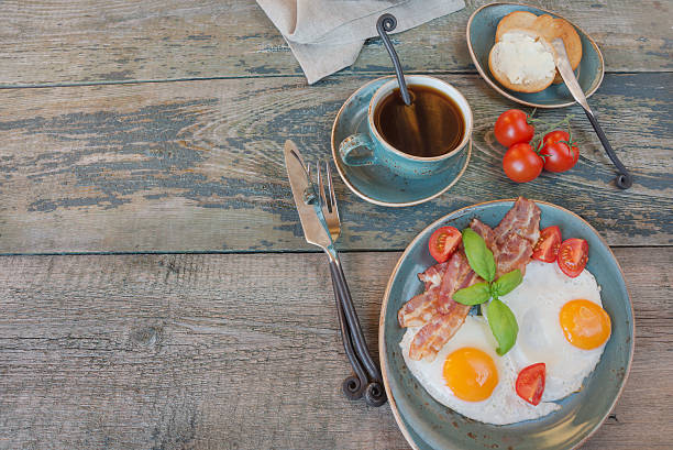 istock Fried eggs,  bacon, tomato, toast and a cup of coffee 588601188