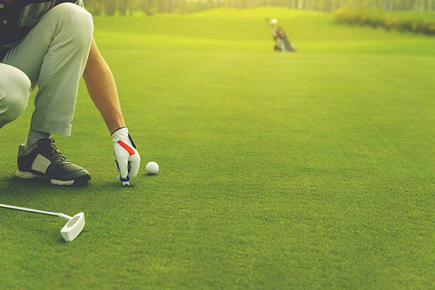 marcando la posición de la pelota de golf en el green - practicing golf putting golf flag fotografías e imágenes de stock