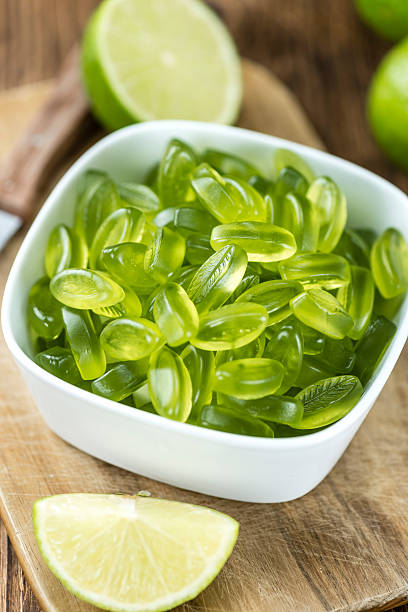 bonbons à la chaux (mise au point sélective) - lime green multi colored sweet food gelatin photos et images de collection