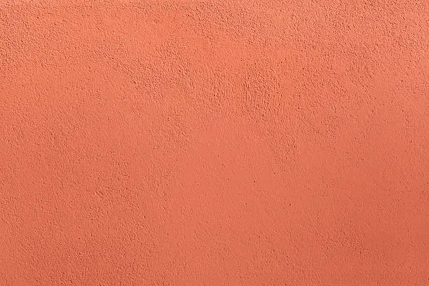 Photo of Terracotta painted stucco wall. Background texture