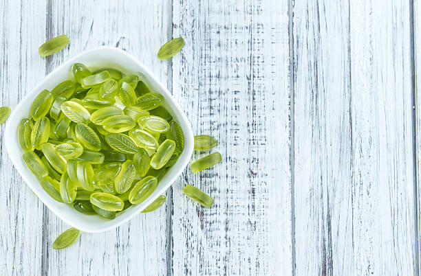 bonbons gommeux avec goût de citron vert (mise au point sélective) - lime green multi colored sweet food gelatin photos et images de collection