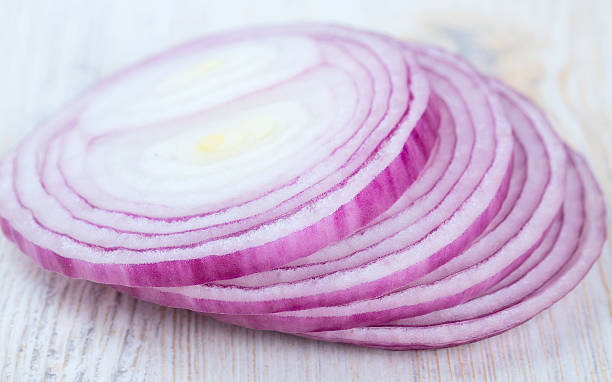 istock slices of red onions on white wooden surface 588603910