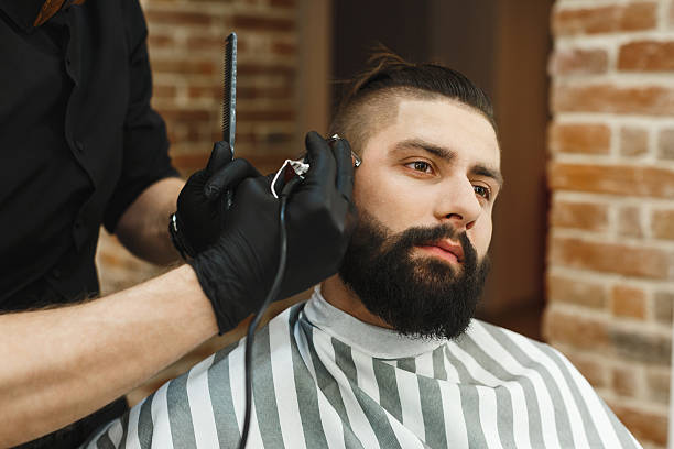 istock Man with dark hair doing a haircut 588604066