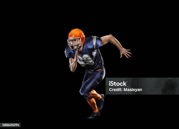 Professional American Football Player In Action Isolated On The Black Stock Photo - Download Image Now
