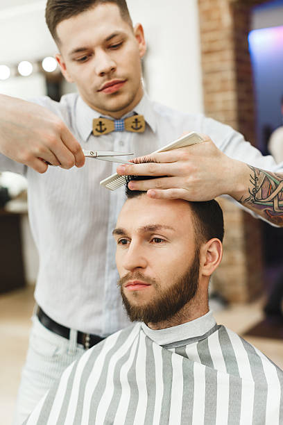 istock Man with dark hair doing a haircut 588605892