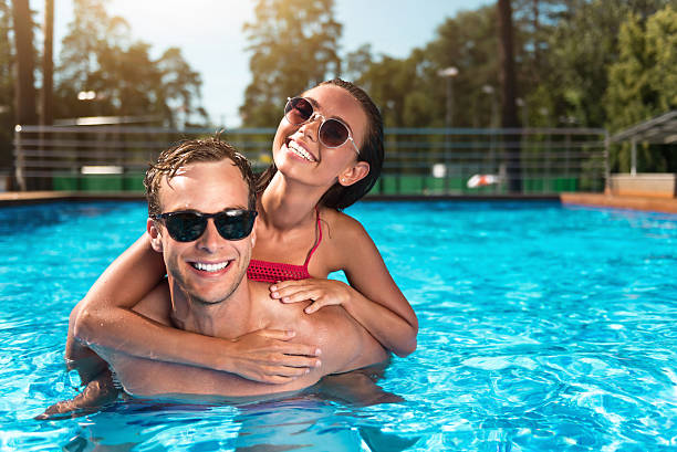 istock Cheerful couple swimming in a pool 588606200
