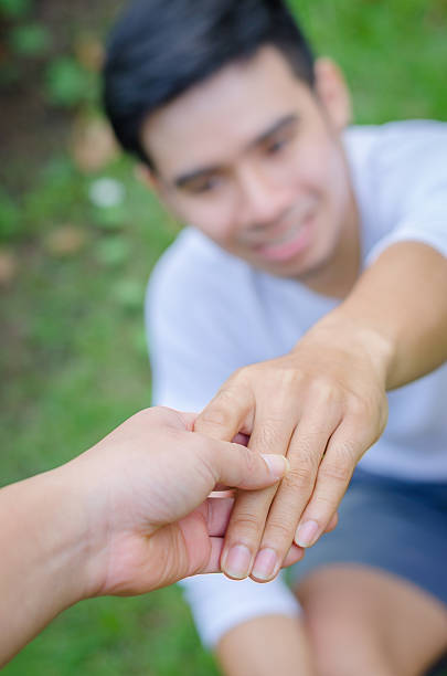 istock Young Asian man shaking hands outdoors 588609310