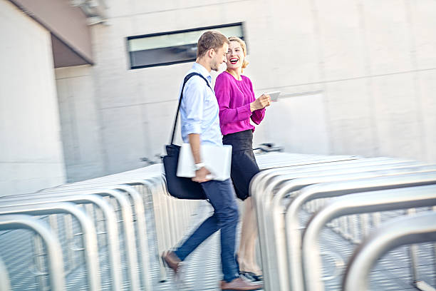 istock Two young businesspeople running late for a meeting 588610638