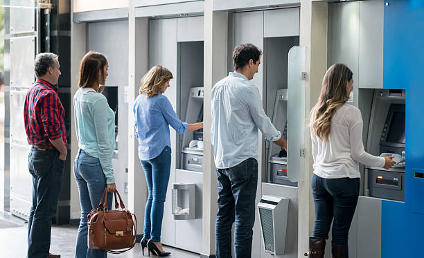 People in a line at an ATM Group of people in a line at an ATM waiting to make a cash withdrawal atm photos stock pictures, royalty-free photos & images