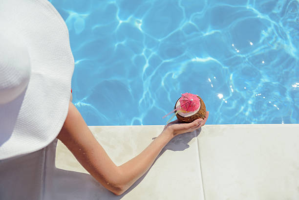 istock Elegant young girl drinking beverage on vacation 588611484