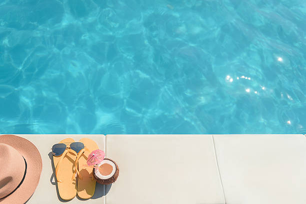 istock Yellow slippers with drink and cap near water 588611658