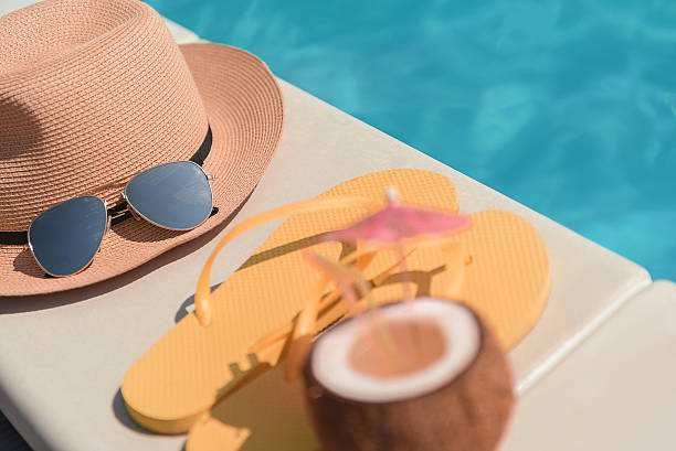 istock Hat and slippers with beverage near water 588611722