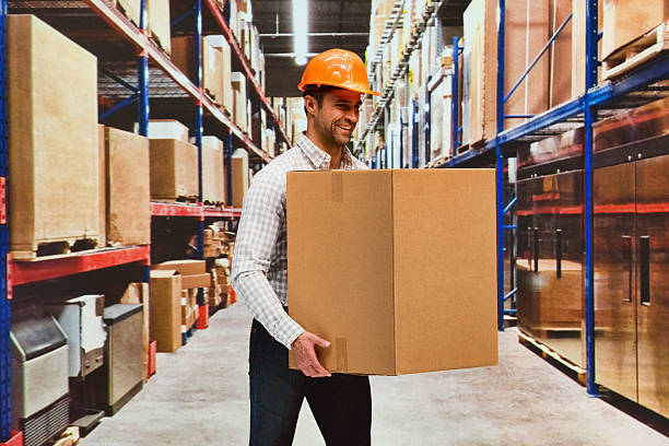 istock Smiling delivery person carrying box in warehouse 588612318