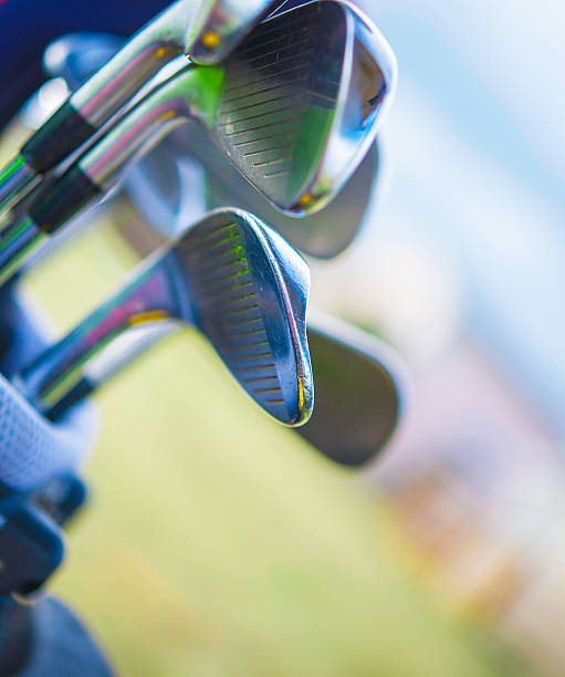 istock Golf clubs in bag in front of defocused golf course 588612708