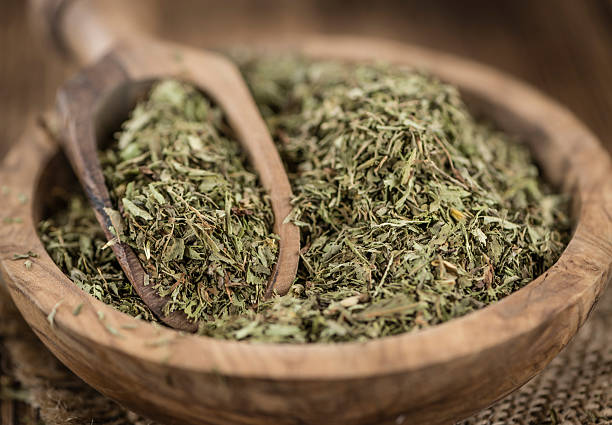 istock Old wooden table with dried Stevia leaves (selective focus) 588613572