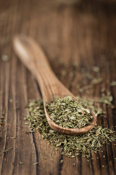 istock Old wooden table with dried Stevia leaves (selective focus) 588613856