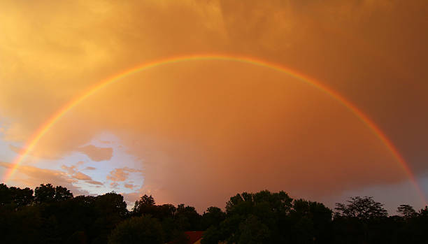 Full Rainbow in a dusk sky stock photo