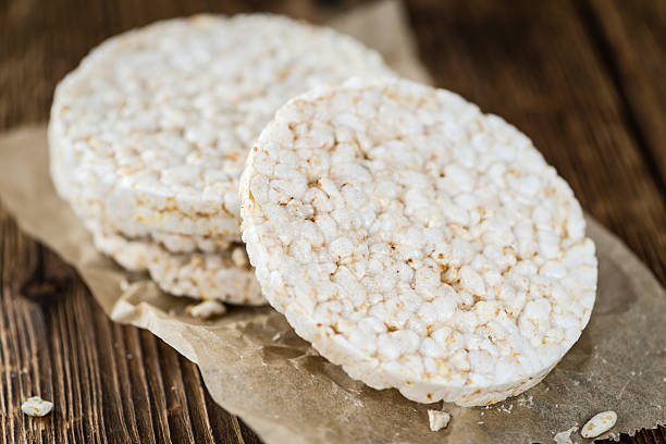 Portion of Rice Cakes Some Rice Cakes (close-up shot) on an old wooden table RICE CAKE stock pictures, royalty-free photos & images