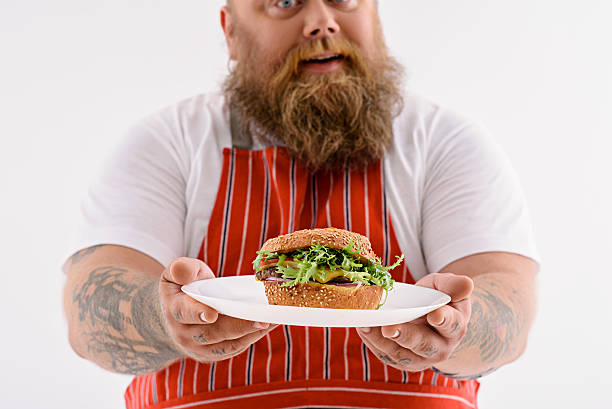 istock Happy thick male chef presenting burger 588616064