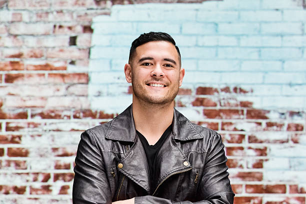 istock Smiling man in front of brick wall 588616408
