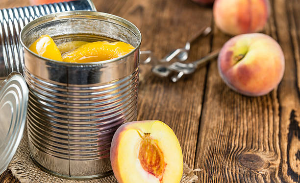 Portion of preserved Peaches Portion of preserved Peaches (close-up shot) on wooden background canned food stock pictures, royalty-free photos & images
