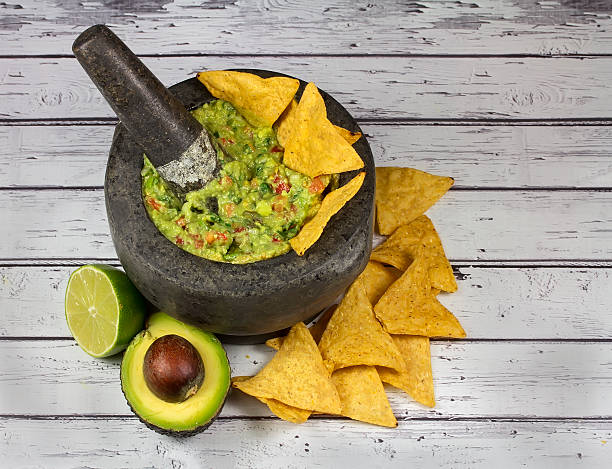 istock Guacamole in granite molcajete mortar on old wooden background 588618762