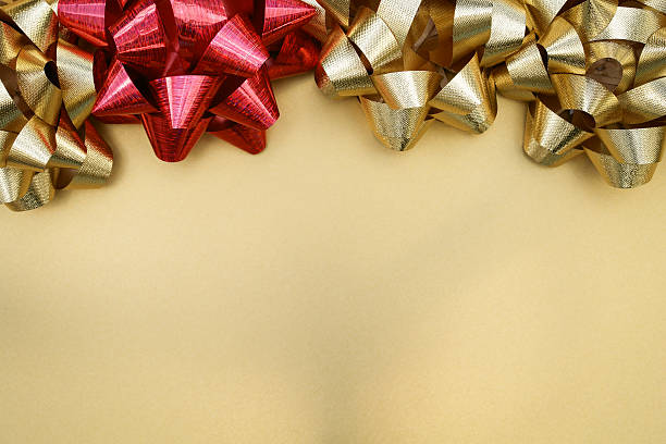 Gold and red ribbon bows on fabric stock photo
