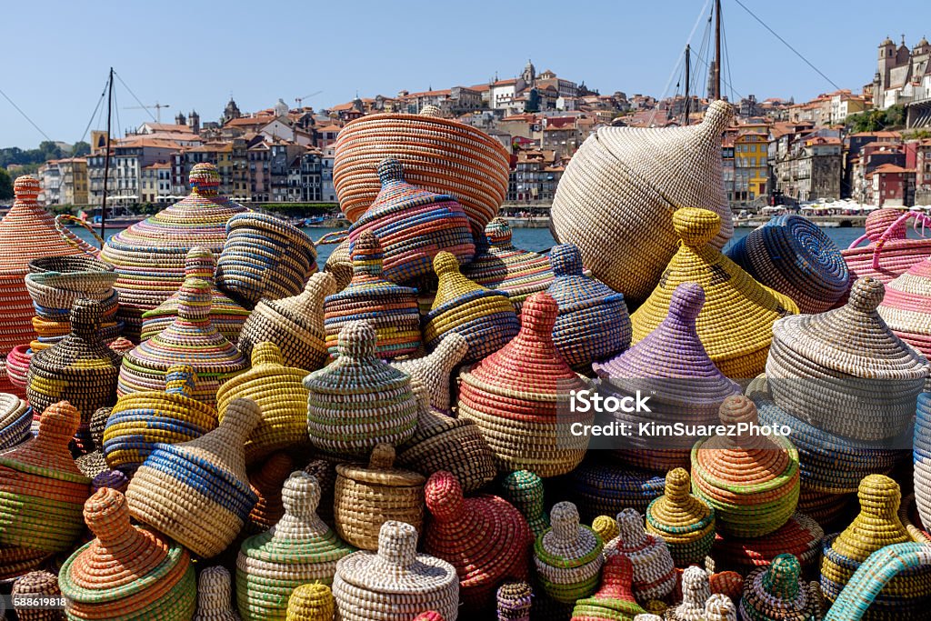 Woven Baskets For Sale on Douro River, Porto A vendor selling woven baskets at a market on the edge of the Douro River in Porto, Portugal. Basket Stock Photo