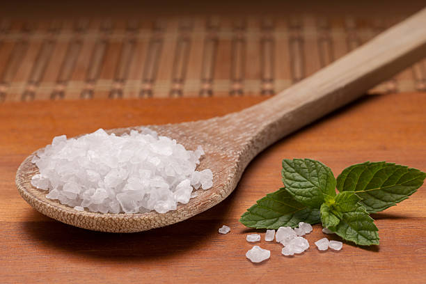istock Sea salt mineral on wooden spoon. 588620916