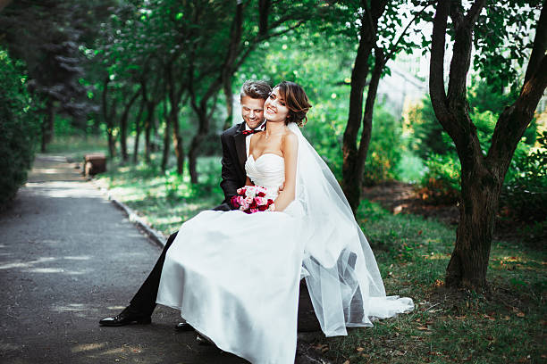 istock Bride and groom sitting on bench 588622244
