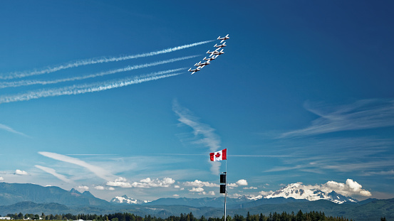 Abbotsford, British Columbia, Canada - August 13, 2016: Canadian Forces Snowbirds aerial demonstration team in formation over the Canadian Rocky Mountains at the Abbotsford International Airshow.