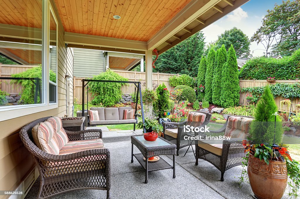 Cozy covered sitting area with wicker chairs and swing Cozy covered sitting area with wicker chairs and swing bench. Northwest, USA Outdoors Stock Photo