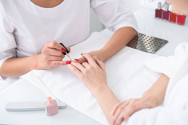 istock Skillful beautician doing manicure for girl 588625902