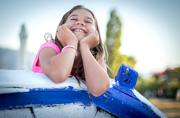 Summer portrait of cute little girl sitting on boat