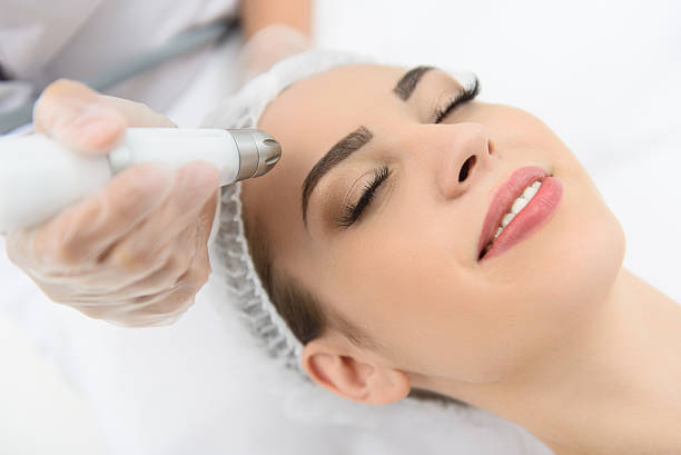 istock Cheerful woman getting laser therapy at spa salon 588626026