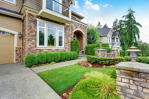 Beautiful curb appeal of American house with stone trim Beautiful curb appeal of American house with stone trim and perfectly trimmed shrubs. Northwest, USA landscaped stock pictures, royalty-free photos & images