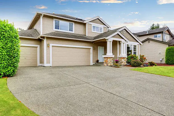 Photo of Neat beige home with two garage spaces.