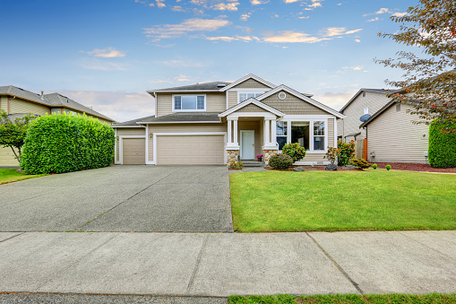 Neat beige home with two garage spaces and large concrete driveway. Northwest, USA