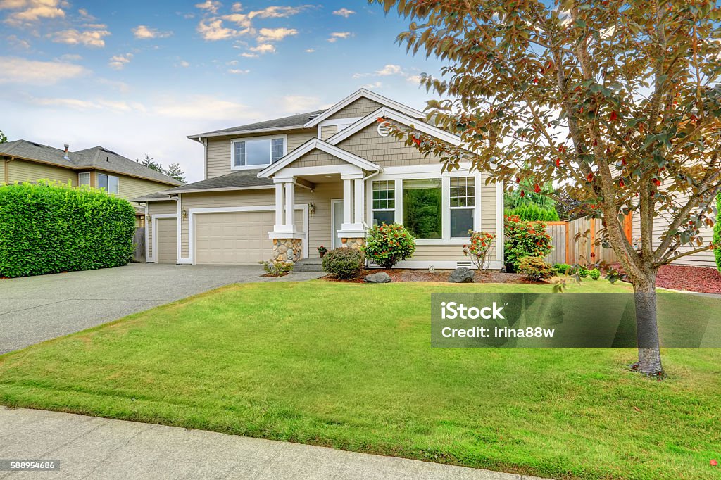 Neat beige home with two garage spaces. Neat beige home with two garage spaces and well kept front garden. Northwest, USA House Stock Photo