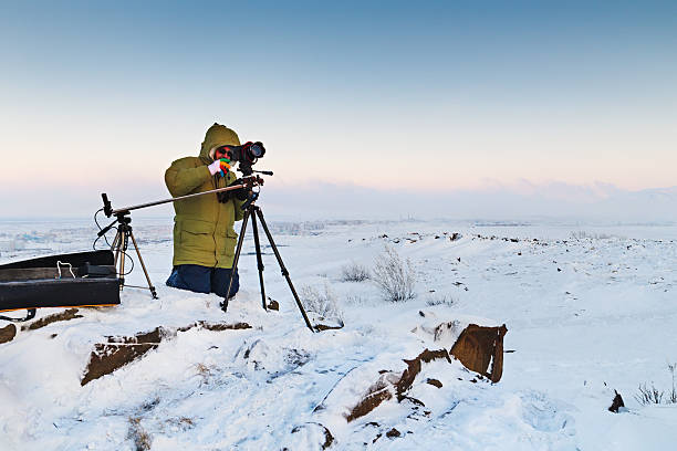 istock Man with photo camera on tripod taking timelapse photos in 588957496