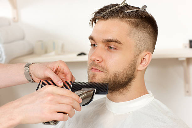 istock Barber gives the client the optimum length beard. 588958388