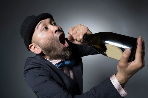 drunk man with bottle of alcohol in hand and green robe drinking relaxation. High quality photo