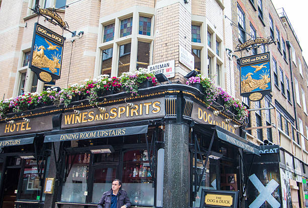 London, England - August 13, 2016: This pub in Soho is renowned for its glazed tile interior. It was built in 1897 on the site of Duke of Monmouth's home and has hosted George Orwell, John Constable and Madonna. It is a Nicholson's pub. People can be seen in the background.