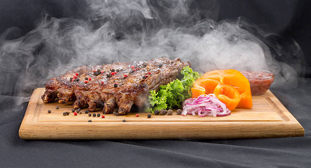 istock grill ribs with smoke with sauce and vegetables 588961768