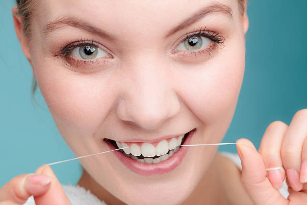 istock Woman face smiling with dental floss. 588962454