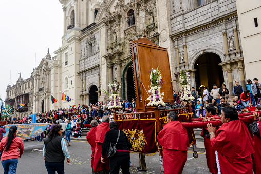 Lima, Peru - June 12, 2016: Religious celebration in front of the Lima Cathedral.  Large crowds of people are gathered to watch a procession with tranditional folkloric dancers and religious artifacts and floats.